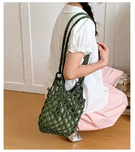 Vintage green hollow-out woven net shoulder bag carried by a model in lifestyle view.
