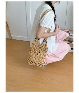 Handmade hollow woven mesh shoulder bag for women in a vintage beige lifestyle shot