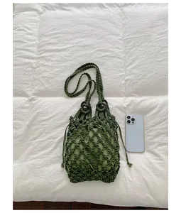 Green hollow-out woven handbag size comparison with smartphone
