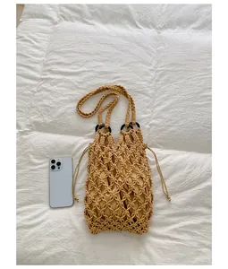 Detailed view of handwoven macrame bag with mesh design and smartphone for scale reference
