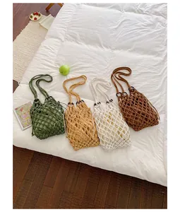 Four stylish hollow-out mesh shoulder bags in various colors displayed on a white bed