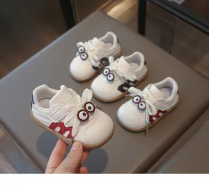 Detailansicht von Kinder-Sneakern aus weißem Leder mit lustigen Augenmotiven und weicher Sohle.