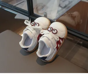 Detailansicht der weißen Kinderledersneaker mit verspielter Cartoon-Augen-Dekoration
