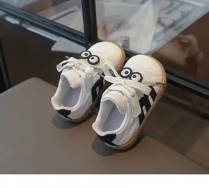 Detailansicht der weißen Kinderlederschuhe mit niedlichen Augen und schwarzem M