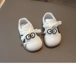 Detailaufnahme von weißen Kinder-Ledersneakern mit weicher Sohle und Cartoon-Augen