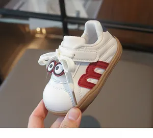 Detailansicht weißer Kinder-Sneaker aus Leder mit rotem M-Logo und Comic-Augen.
