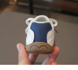 Detailansicht der weißen Kinder-Sneaker mit blauem Fersenelement und brauner Gummisohle