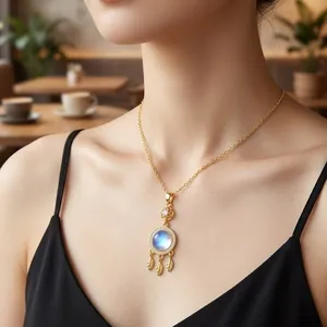 Elegante goldene Traumfänger-Halskette mit blauem Stein und Federanhängern an einem Model.