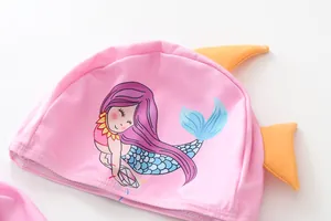 Close-up of pink girls' swim cap with cute cartoon mermaid print and 3D fins