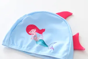 Detailed view of a cute light blue kids swim cap featuring mermaid print and pink fins