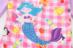 Macro detail of the cute mermaid cartoon print on pink checkered girls' swimwear