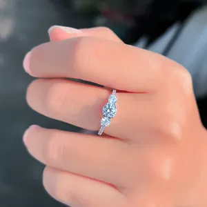 Detailansicht eines klassischen Silberrings mit drei funkelnden Diamanten auf einem Finger