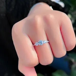Detailansicht eines S925 Sterlingsilber-Rings mit drei funkelnden Steinen für die Verlobung.