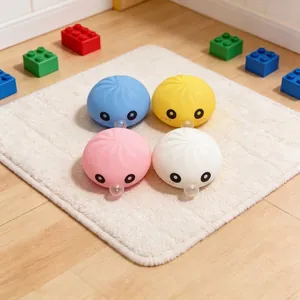 Dettaglio di quattro giocattoli colorati a forma di panino su un tappeto bianco