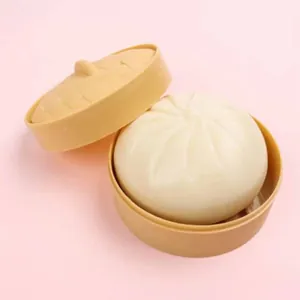Primo piano di un giocattolo a forma di baozi all'interno di un mini cestino vapore.