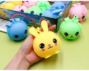 Gedetailleerd beeld van een hand die een geel konijn squishy speeltje vasthoudt