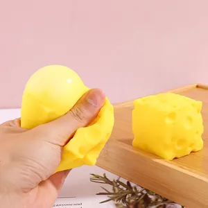 Hand squeezing a realistic yellow cheese shaped squishy toy for creative stress relief