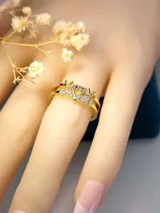 Close-up of gold V-letter ring with pavé cubic zirconia and colorful stones
