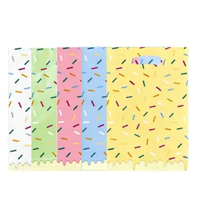 Détail de cinq sacs cadeaux de fête colorés avec des motifs de pépites pour bonbons