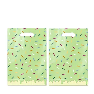 Gros plan sur des sacs cadeaux de fête vert clair avec des motifs de pépites colorés.
