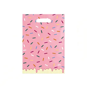 Gros plan d'un sac cadeau rose avec des vermicelles colorés et un motif de glaçage
