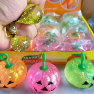 Dettaglio del giocattolo antistress a zucca glitterata con texture e deformazione elastica.