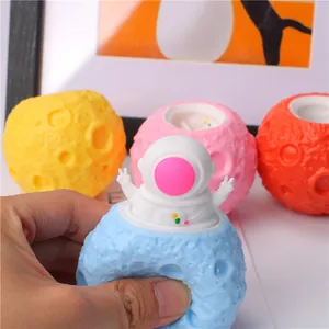 Colorful moon planet astronaut squishy stress relief toy being squeezed by hand