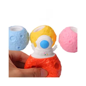 Funny astronaut popping out of a cratered moon cup squeeze toy for stress relief