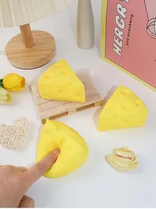 Detailansicht einer Hand, die ein weiches, gelbes Käse-Stressabbau-Spielzeug drückt