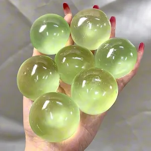 Nahaufnahme von lichtgrünen, lichtdurchlässigen Anti-Stress-Bällen in einer menschlichen Hand