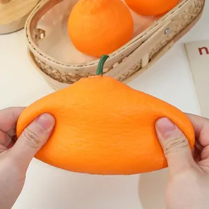 Mani che allungano un giocattolo squishy arancia realistico per un efficace sollievo stress