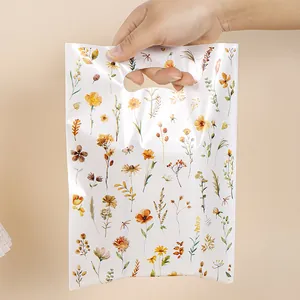 Elegante borsa regalo in pellicola perlata bianca con stampe di fiori selvatici.