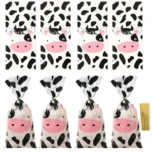 Cartoon cow print party treat bags with gold twist ties for holiday candy packaging