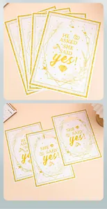 Detailweergave van wit-gouden verlovingscadeautassen met 'She Said Yes' opdruk