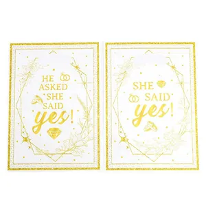 Twee witte en gouden verlovingscadeauzakjes met het ontwerp 'He Asked She Said Yes'