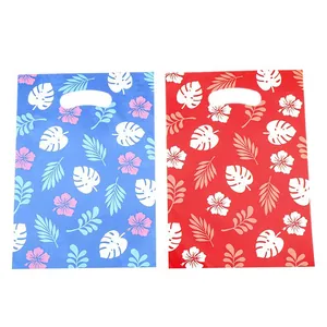 Tropical Hawaiian floral print plastic gift bags with die-cut handles in red and blue