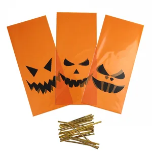 Set of orange Halloween pumpkin gift bags with gold twist ties for candy treats and favors.