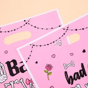 Two pink Halloween party gift bags featuring skull bone and rose prints for treats