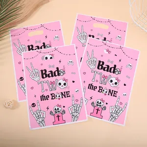 Pink Halloween skeleton party gift bags with a 'Bad TWO the BONE' printed design