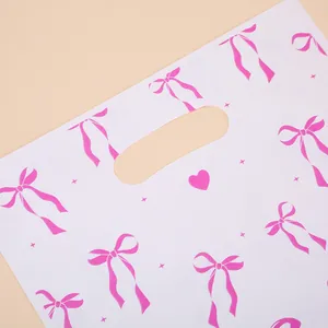 Sac cadeau perlé blanc avec nœuds roses et poignée découpée pour les fêtes