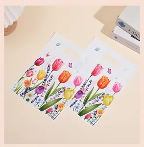 White gift bags with colorful tulip floral prints displayed on a soft cream background.