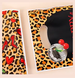 Vista de cerca de una bolsa de regalo de leopardo con patrones de cerezas y corazones