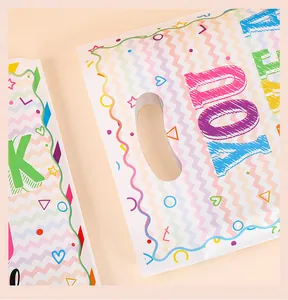 Dettaglio di sacchetti regalo colorati con lettere stampate e manico.