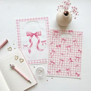 Detailed view of girly pink bow plastic gift bags for birthday party favors and baby showers