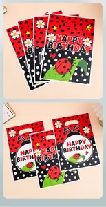 Detail van plastic cadeautassen met lieveheersbeestje-thema en Happy Birthday