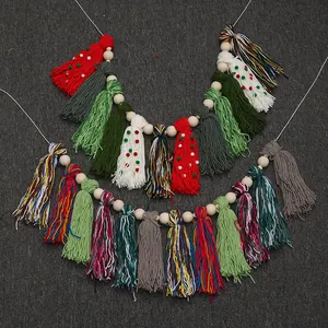 Detailed view of handmade Christmas tassel garland with wooden beads on dark background.