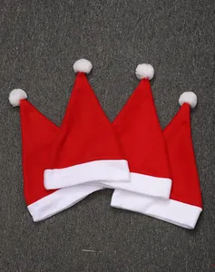 Nahaufnahme von vier klassischen roten Weihnachtsmannmützen auf grauem Hintergrund