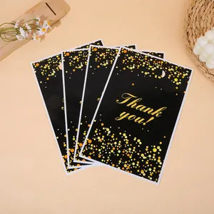 Vier zwarte geschenkzakjes met gouden Thank You print en fonkelende champagnekleurige stippenpatronen