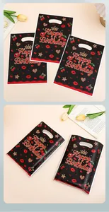 Detailed view of Happy Birthday gift bags with cherry and lip patterns on a desk.