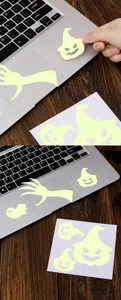 Détail de stickers d'Halloween luminescents sur ordinateur avec motifs fantôme et citrouille